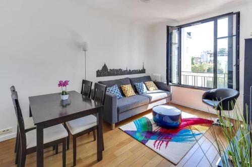 un salon avec un canapé et une table dans l'établissement Appartement Garros - Welkeys, à Boulogne-Billancourt