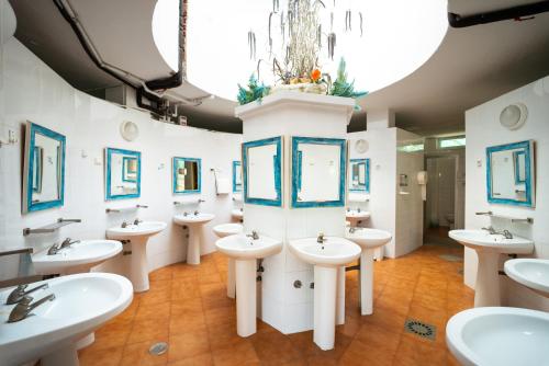 a bathroom with white sinks and mirrors and a chandelier at Kampaoh Costa del Sol in Caserío Almayate Bajo