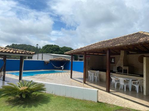 un patio avec une table et des chaises à côté d'une piscine dans l'établissement Pousada clair, à Ibitirama