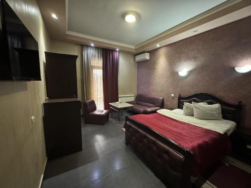 Habitación de hotel con cama y TV en White House Hotel, en Ereván