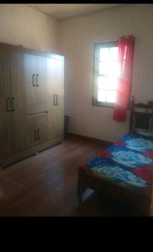 a bedroom with a bed and a window and cabinets at Chácara lua e sol in Pouso Alegre