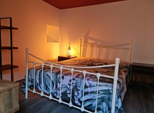 1 dormitorio con 1 cama con marco blanco en Casa da Capela, en Entre Ambos os Rios