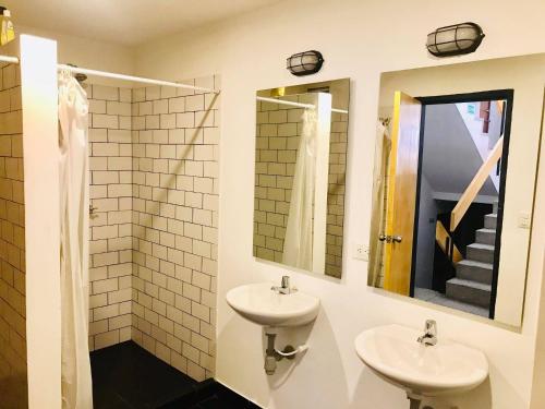 a bathroom with two sinks and two mirrors at Best view Bogota Central Hostel in Bogotá