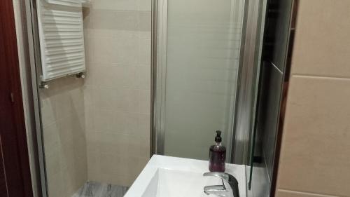 uma casa de banho com um lavatório e um chuveiro em Apartamento Luanco con garaje y piscina VUT4780AS em Luanco