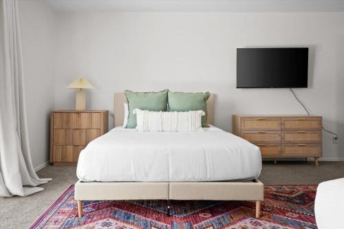 a bedroom with a bed and a flat screen tv at Family FUN Pool Movie Theater PuttPutt in Oro Valley