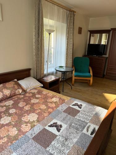 Un dormitorio con una cama y una silla y una ventana. en Tilto 6, en Vilna
