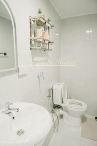 a white bathroom with a toilet and a sink at 2 BR Unit in the heart of Iloilo Self Check-in in Iloilo City