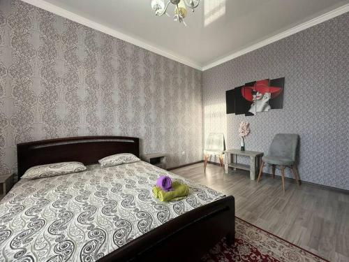 a bedroom with a bed with a teddy bear on it at Студия возле теннисного центра in Aktobe