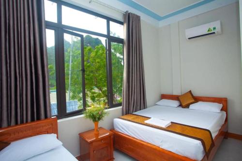 een slaapkamer met 2 bedden en een raam bij Riverview Home in Quang Binh