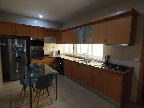 eine Küche mit Holzschränken, einem Tisch und einer Arbeitsplatte in der Unterkunft Sunset Apartment in Praia