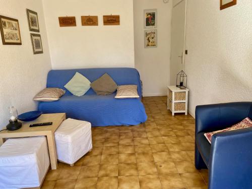 un salon avec un canapé bleu et une table dans l'établissement Bastide, à Saint-Cyprien