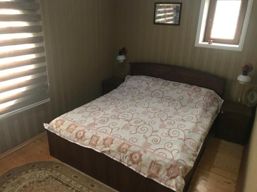 - un petit lit dans une chambre avec une couverture dans l'établissement В БУЗОВНАХ дачный дом у моря, à Buzovna