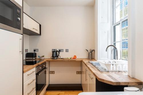 a kitchen with a wooden counter top and a sink at Stay Trafalgar Square in London