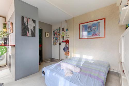 een slaapkamer met een bed in een kamer bij Résidor - Cozy studio 10 minutes from Paris in Les Lilas
