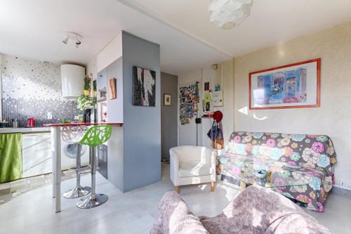 een woonkamer met een bank en een tafel bij Résidor - Cozy studio 10 minutes from Paris in Les Lilas