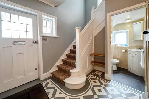 a bathroom with a staircase with a toilet and a sink at Stunning house, sleeps 10, garden and pool table - West Parley Manor in West Parley