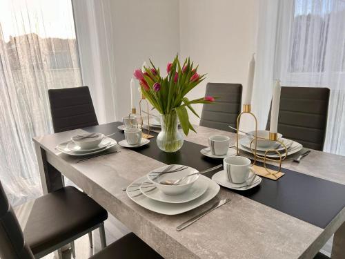 - une table à manger avec un vase de fleurs dans l'établissement Apartment Weikersheim II, à Weikersheim