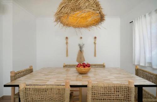 a dining room table with a bowl of fruit on it at Boho Chic Beach Duplex in Sesimbra