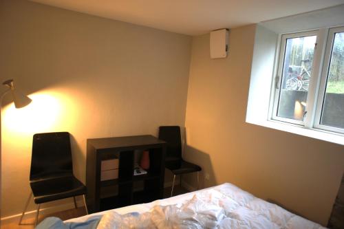 1 dormitorio con 2 sillas, 1 mesa y 1 cama en (id116) Nørregade 51 kld tv en Esbjerg