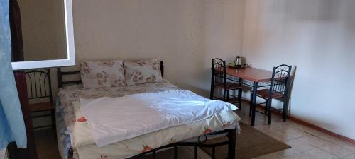 Dormitorio pequeño con cama y mesa en ARBA hotel, en Ereván