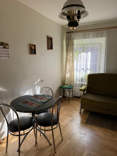 Una sala de estar con una mesa y sillas y un sofá. en Tilto 6, en Vilna