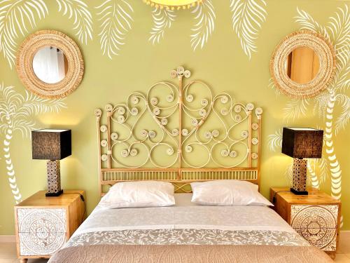 a bedroom with a bed with two lamps and two mirrors at Elegant seaview apartment Praia da Rocha in Portimão