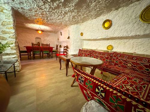 uma sala de estar com cadeiras vermelhas e uma mesa em Casa del Juez, Alojamiento rural singular em Alcalá del Júcar