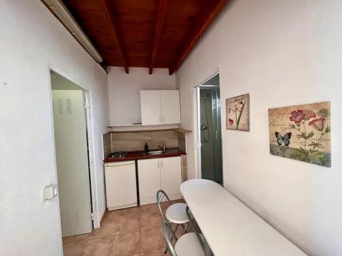 a small kitchen with a counter and chairs in a room at Integral surf yoga in El Médano