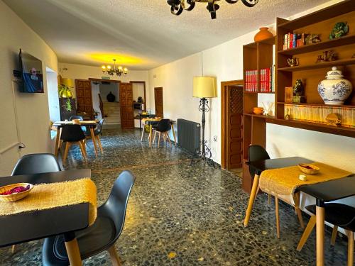 un restaurante con sillas y mesas y una sala con mesas en Casa del Juez, Alojamiento rural singular, en Alcalá del Júcar