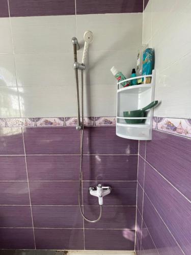 y baño con ducha de azulejos morados. en Traditional forest villa, 