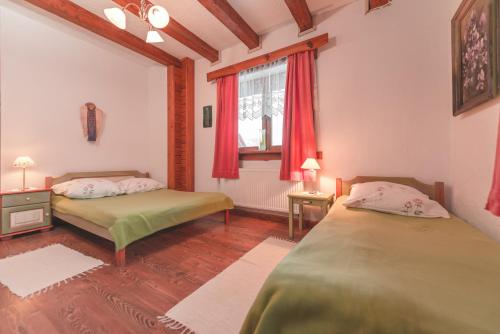 a bedroom with two beds and a window at Sosnowy Dwór in Cisna