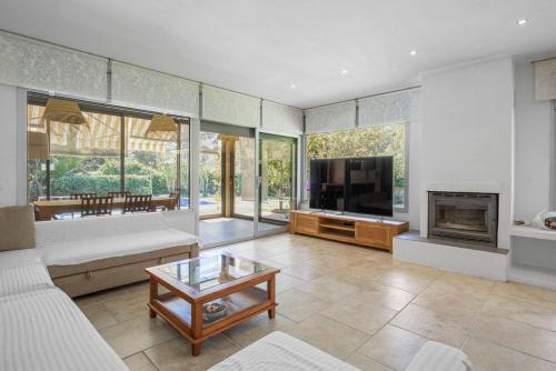 a large living room with a tv and a fireplace at Villa Montgó in L'Escala