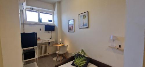 ein Wohnzimmer mit einem Sofa, einem Tisch und einem TV in der Unterkunft PescaraHome Monolocale Essential in Pescara