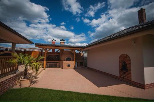a house with a courtyard with a patio and a house at Penzión Daniela in Veľký Meder