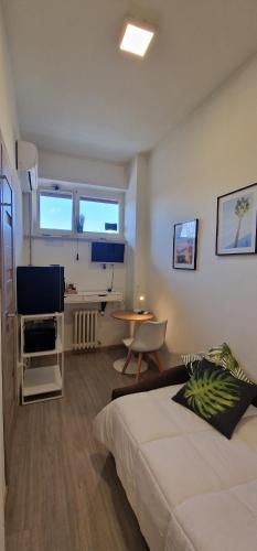 Schlafzimmer mit einem Bett, einem Schreibtisch und einem TV in der Unterkunft PescaraHome Monolocale Essential in Pescara