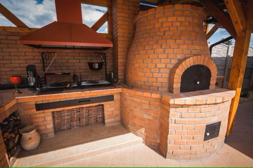an outdoor kitchen with a brick oven in a patio at Penzión Daniela in Veľký Meder