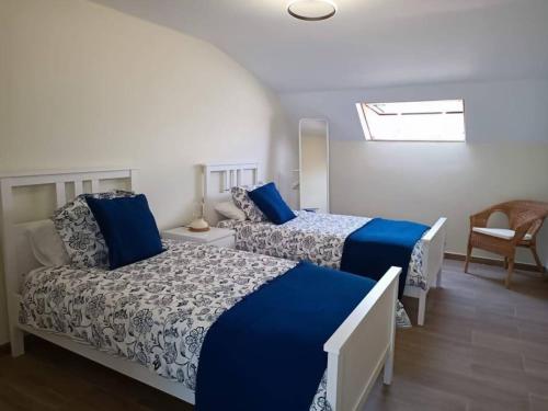een slaapkamer met 2 bedden met blauwe en witte lakens bij Apartamento RyR in Padrón