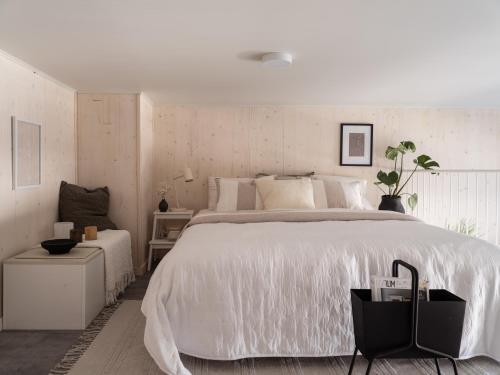 1 dormitorio con 1 cama grande con edredón blanco en Waterfront Cabins, en Gotemburgo