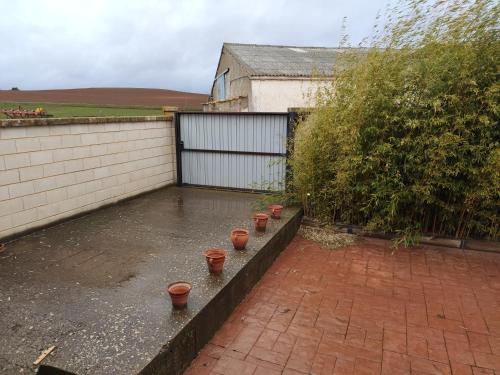 a backyard with a row of pots on the ground at Casa Maite in Ríoseco de Soria
