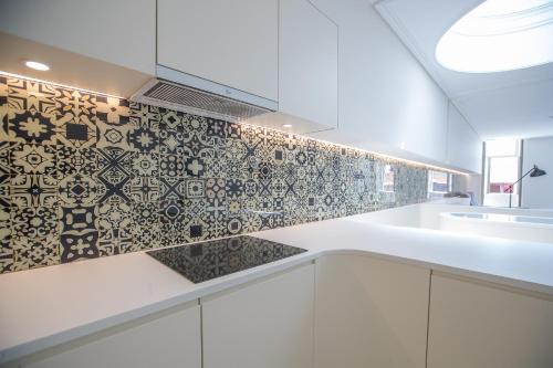 een keuken met zwarte en witte tegels op de muur bij Porto D'Alma Santa Catarina Apartments in Porto