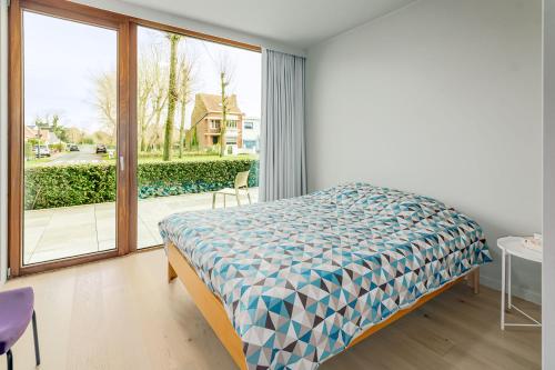 a bedroom with a bed and a large window at Maremonte Gv02 in Oostduinkerke
