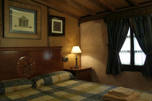阿拉爾孔的住宿－La Posada del Hidalgo de Alarcón，一间卧室配有床、灯和窗户