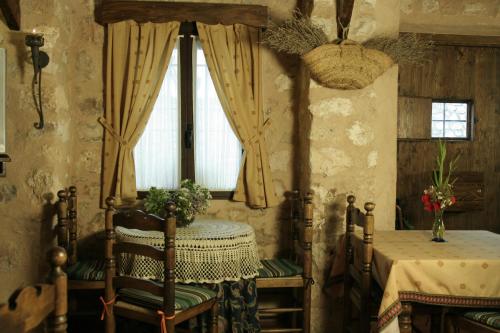 comedor con mesa, sillas y ventana en La Posada del Hidalgo de Alarcón, en Alarcón