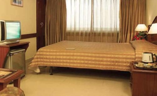 Ένα ή περισσότερα κρεβάτια σε δωμάτιο στο Nandhini Deluxe Hotel