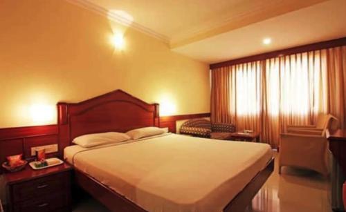 מיטה או מיטות בחדר ב-Nandhini Deluxe Hotel