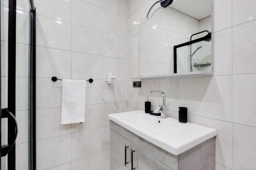 a white bathroom with a sink and a mirror at Studio with Terrace 5 min to Coast in Istanbul