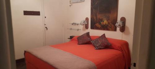 a bedroom with a bed with red sheets and pillows at LA MENDOZA in San Miguel de Tucumán