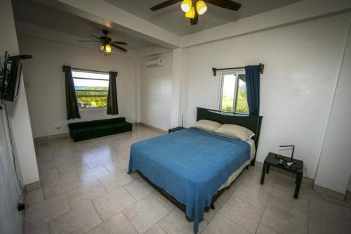 - une chambre avec un lit bleu et un canapé dans l'établissement The spot in Tarpon Bay, à San Pedro