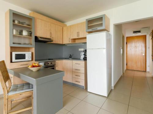 een keuken met een witte koelkast en een fruitschaal op een aanrecht bij Like Home Apartman Balatonőszöd in Balatonőszöd