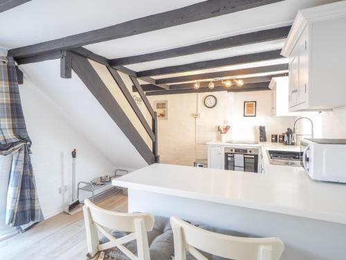 a kitchen with white counters and white cabinets at The Coach House Newcastle Emlyn in Newcastle Emlyn
